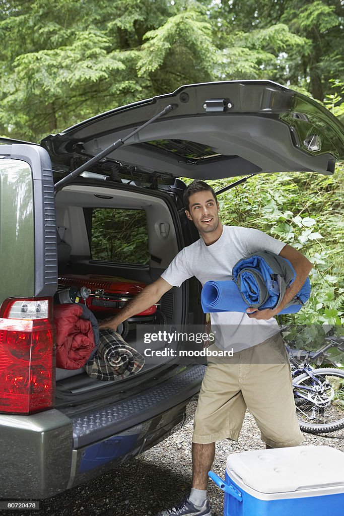Man unloading car in countryside