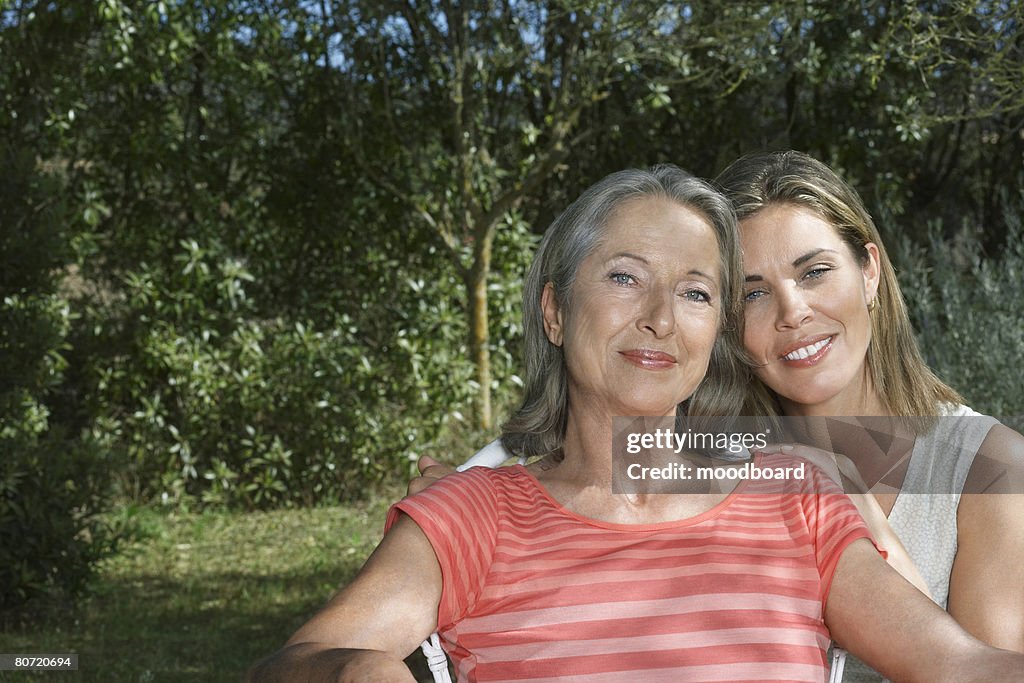 Portrait of mother with adult daughter in garden