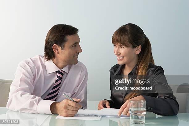 business man and woman working at table in office - business revenge stock pictures, royalty-free photos & images