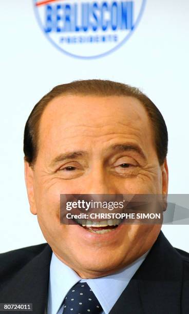 Italy's prime minister-elect Silvio Berlusconi smiles during a press conference with Italy's populist Northern League leader Umberto Bossi, President...
