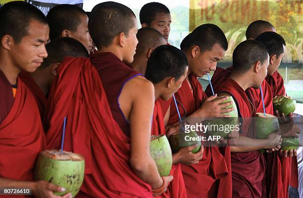 Tibetan monks drink coconuts as they break their 24-hour hunger strike near the Indira Maidan on the outskirts of Siliguri on April 17, 2008. Some 60...