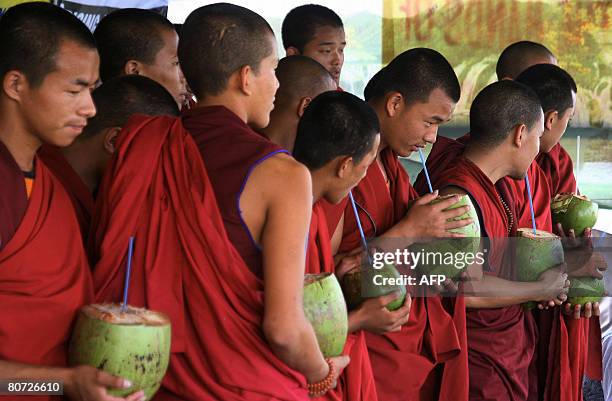 Tibetan monks drink coconuts as they break their 24-hour hunger strike near the Indira Maidan on the outskirts of Siliguri on April 17, 2008. Some 60...