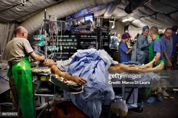 British Army Anaesthetist Lt. Col. Ian Hicks prepares injured British Army soldier Simon Peacock from the Royal Anglion Regiment for surgery at the...