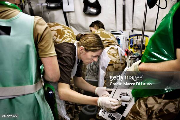 British Army Intensive care nurse Lt. Vicki Rigby looks at a monitor to assess the vital signs of British Army soldier Pte Alexander Harrison from...