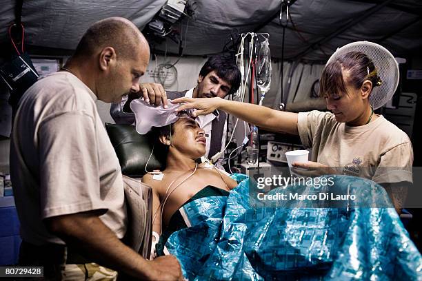 British Army operating department practitioner assist Afghan National Police officer Akbar after his surgery at the operating theatre on June 7, 2007...