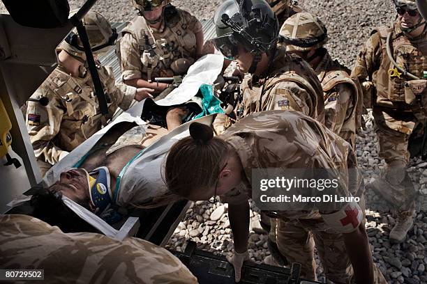 British Army Medical Emergency Response team from the UK Med Group load Afghan National Army soldier, Bashir into an ambulance as he is brought in by...