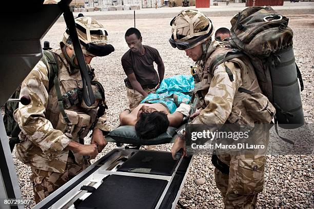 British Army Medical Emergency Response team from the UK Med Group load Afghan National Police officer Akbar into an ambulance as he is brought in by...