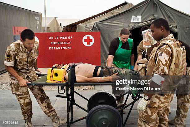 British military medical personnel from the UK Med Group carry Afghan National Army soldier Sgt. Sardaron on a gurney as he arrives at the British...