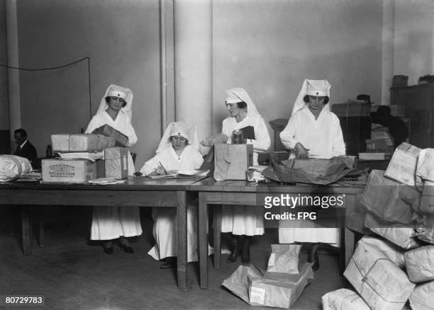 Nurses at Rec Cross headquarters in New York preparing Christmas parcels for American prisoners of war who are held in Germany, circa 1916.