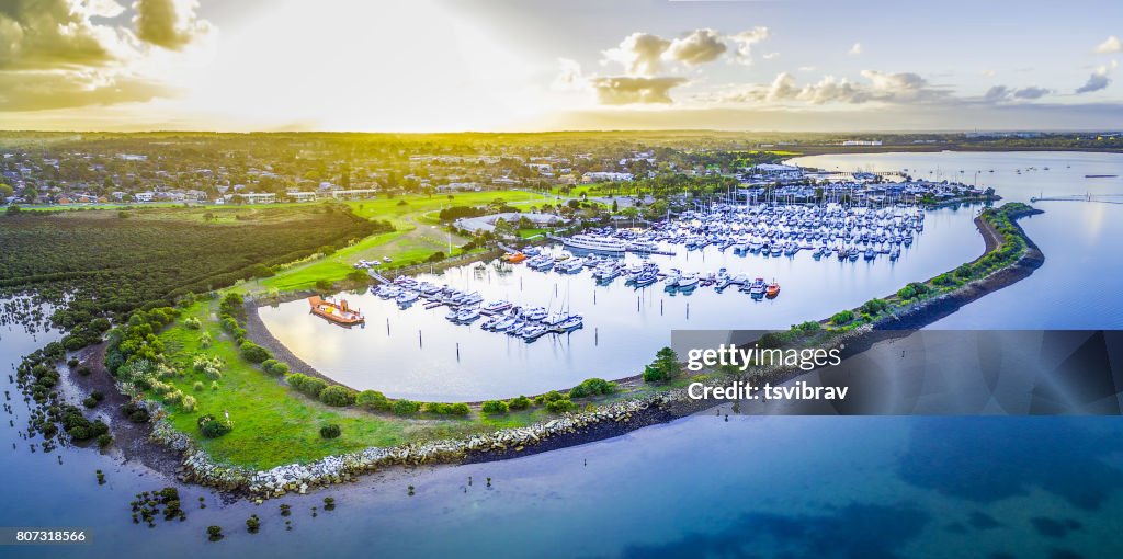 Aerial view of Westernport Marina with moored boats and Hastings coastline at beautiful sunset. Melbourne, Victoria, Australia