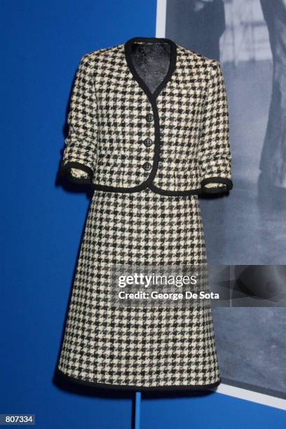 Jacqueline Kennedy wore this black-and-white houndstooth wool tweed suit with black braided trim by Bob Bugnand, inspired by the classic Chanel suit,...