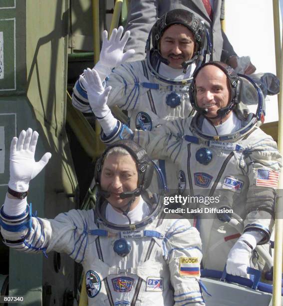 Dennis Tito, center, the world's first space tourist, waves while boarding the Soyuz TM-32 spaceship April 28, 2001 at the Baikonur cosmodrome in...