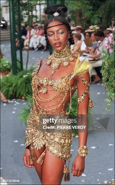 British top model Naomi Campbell presents an Indian dancing girl evening ensemble consisting of a bra and sarong mini-skirt, with a choker, ruff,...