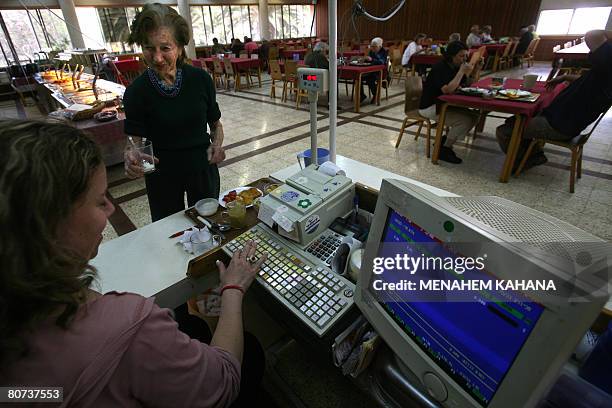 Riva Kippins buys her meal at a cantine in Israel's oldest kibbutz, Deganya Alef, on the shores of the Sea of Galile on April 1, 2008. Much has...