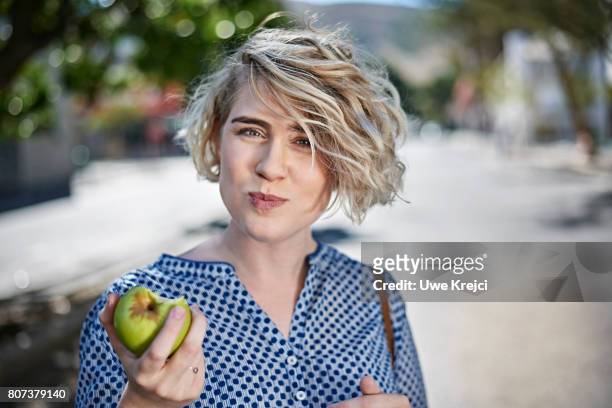 young woman eating green apple - woman eating fruit stock pictures, royalty-free photos & images