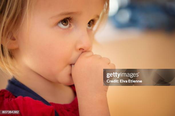 shy child (4-5) sucking thumb for reassurance - chuparse el pulgar fotografías e imágenes de stock