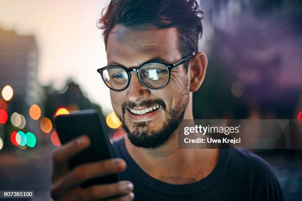 young man reading text message - street light imagens e fotografias de stock