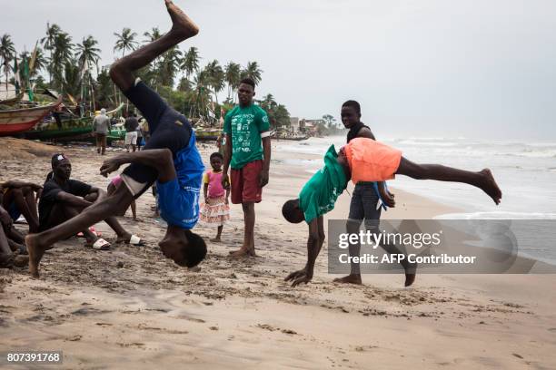 Surfers do flips as they wait to compete in the international surf day competition in Kokrobite Beach, Ghana on June 18, 2017. The beach, some 30...