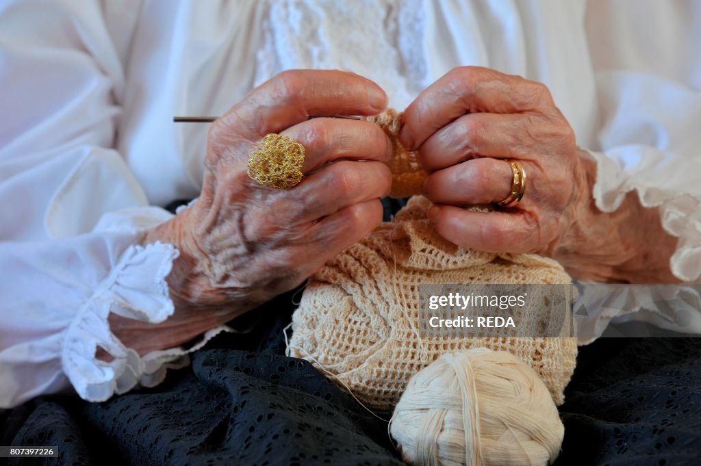Ancient woman at work with typical Sardinian jewelry. Baunei. Sardinia. Italy. Europe