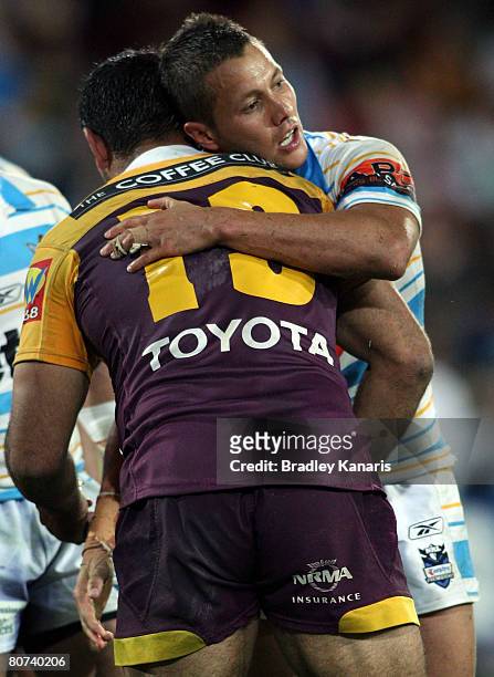Scott Prince of the Titans and Tonie Carroll of the Broncos embrace after the round six NRL match between the Gold Coast Titans and the Brisbane...