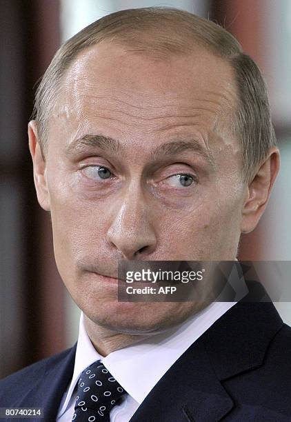 Outgoing Russian President Vladimir Putin grimaces during a press conference at Italian Prime Minister-elect Silvio Berlusconi's private summer...
