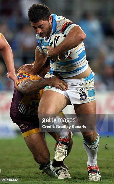 Mark Minichiello of the Titans pushes away from the Broncos defence during the round six NRL match between the Gold Coast Titans and the Brisbane...