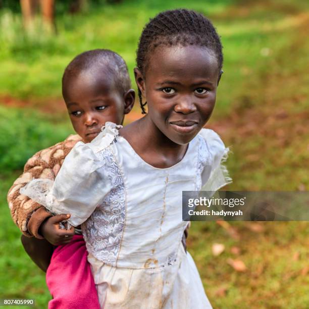 pequena garota africana segurando seu bebê irmã, quênia, no leste da áfrica - cultura tribal africana - fotografias e filmes do acervo