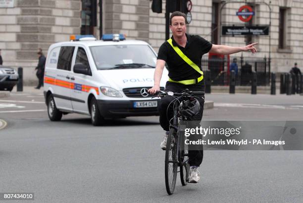 Conservative Party Leader David Cameron arrives by bicycle at the House of Commons in central London, for the last Prime Minister's Question Time...
