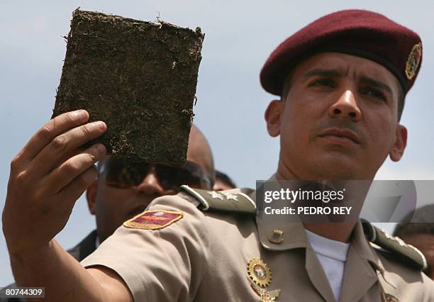 National Guard officer shows a brick of marijuana, part of three tons of drugs to be incinerated at a military barracks in Caracas on April 18, 2008....