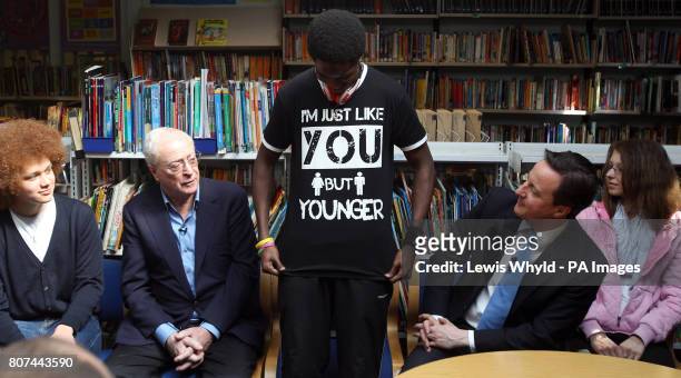 Conservative Party Leader David Cameron with film star Sir Michael Caine look at the T-shirt of student Daryl Brown at the Globe Academy in...