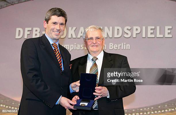 Theo Zwanziger , president of the German Football Association hands over a medal to referee Markus Merk during the DFB German Football Association...