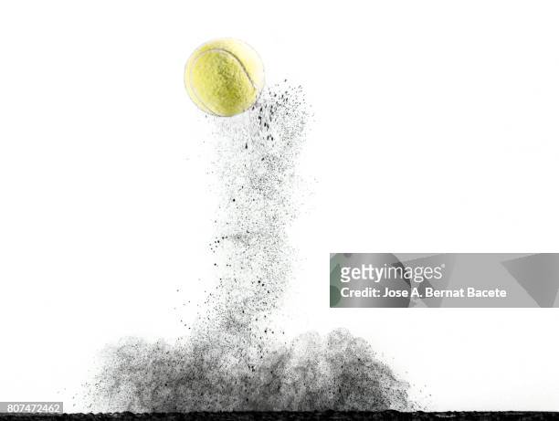 Impact and rebound of a ball of tennis on a surface of land and powder on a white background