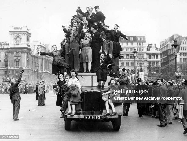 View of revellers, including local young men and women along with soldiers and sailors from Britain's armed forces, celebrating on top of a lorry as...