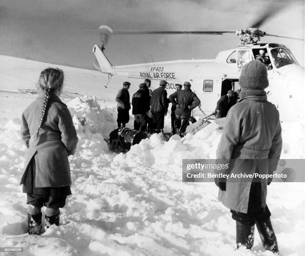 Weather Snow. pic: 8th January 1963. Stranded families, cut off by deep snow in the Lammermuir Hills, Scotland, greet a RAF. helicopter which was delivering supplies to isolated farms.