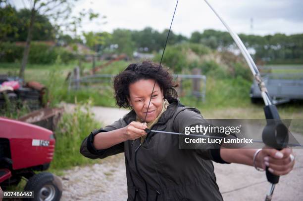 woman shooting bow and arrow - 807453486,807453502,807453516,807462304,807462308,807462298,807462302,807462360,807462344,807462326,807462330,807462374,807480870,807484068,807484070,807484072,807486462,807486494,807486458,807486466 stockfoto's en -beelden