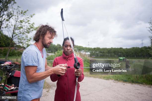 woman learning and preparing to shoot bow and arrow - studying hard stock pictures, royalty-free photos & images