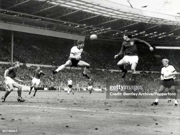 World Cup Final 30th July Wembley Stadium, England, England 4 v West Germany 2, West Germany's Wolfgang Weber and England's Martin Peters both jump...