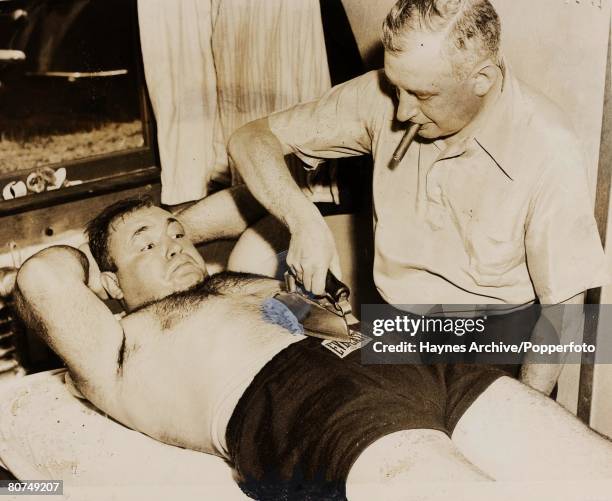 Boxing America, A picture of the heavyweight -Two ton' Tony Galento has his stomach ironed flat by manager Mike Jacobs prior to his World heavyweight...