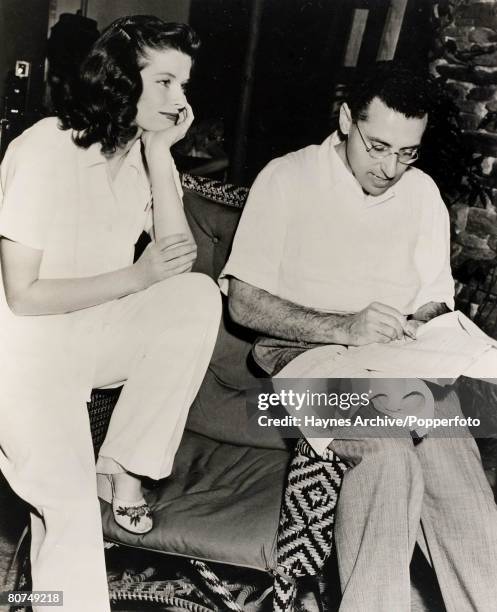 Picture of the American Film actress Katharine Hepburn talking over the script of the film "The Philadelphia Story," in Hollywood with director...