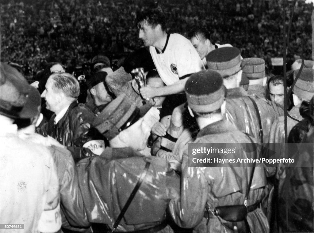 Football 4th July 1954. World Cup Finals. Berne, Switzerland. Finals. West Germany 3 v Hungary 2. The victorious West German captain Fritz Walter is chaired off the pitch clutching the Jules Rimet Trophy after the match.