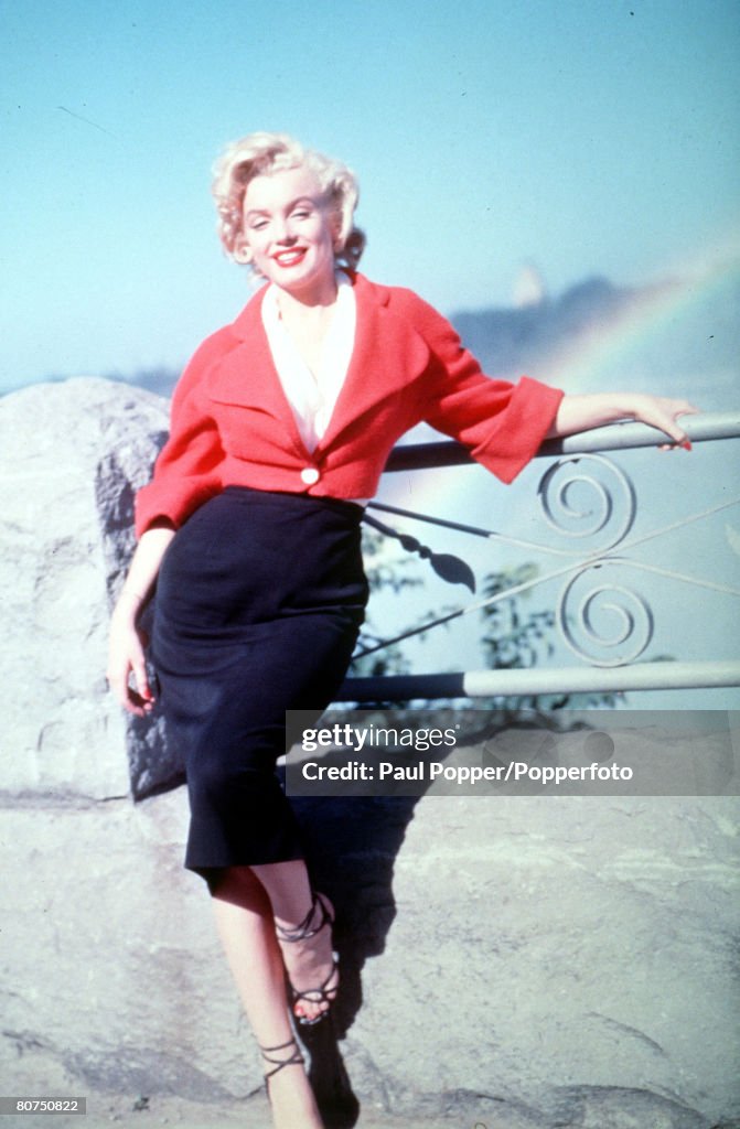 Legendary American film actress Marilyn Monroe poses against a railing