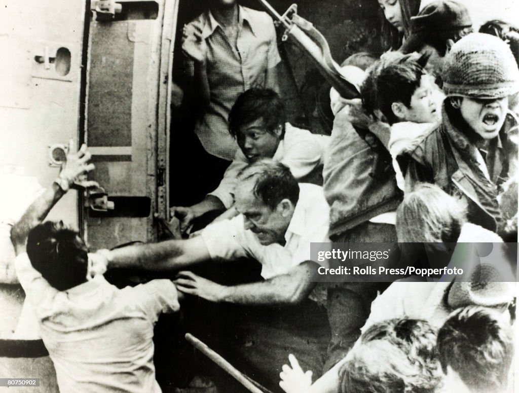 War and Conflict The Vietnam War. pic: 1975. Nha Trang, South Vietnam. An American official punches a man in the face as an already overloaded evacuation helicopter is about to be "swamped" by others trying to board in the scramble to reach safety ahead