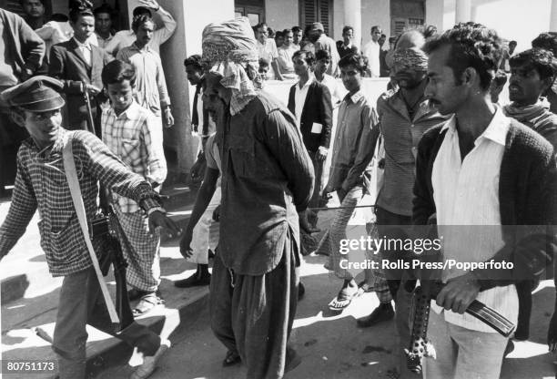 Dacca, East Pakistan, pic: circa 1971, Blindfolded and with hands tied, two prisoners, are led through Dacca and to jail by a group of Mukti Bahini...