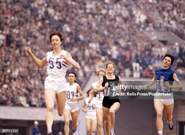 English athlete Ann Packer crosses the finish line in first place, ahead of 2nd placed Maryvonne Dupureur of France and 3rd placed Marise Chamberlain...