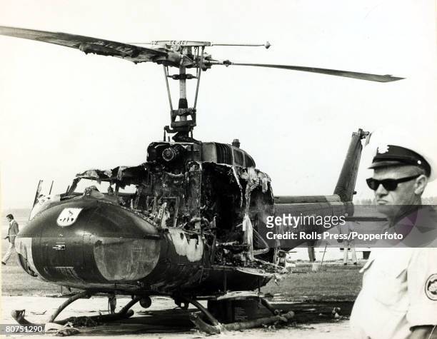 West German Bundesgrenzschutz officer standing guard near a grenade damaged Bell UH-1 helicopter on the day after a gun battle between West German...