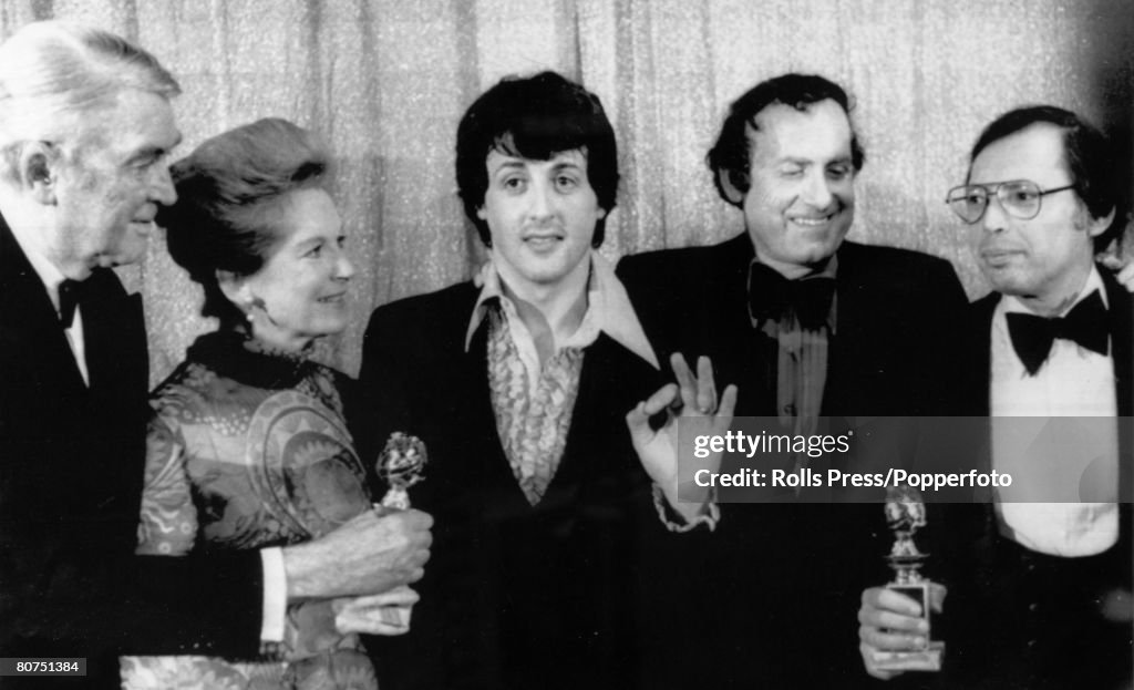 Stage and Screen Personalities. pic: 30th January 1977. Hollywood, U.S.A. James Stewart, left accompanied by Mrs. Stewart presents the Golden Globe awards "Best Motion Picture Drama" to the star and writer of "Rocky" Sylvester Stallone, centre and Produc