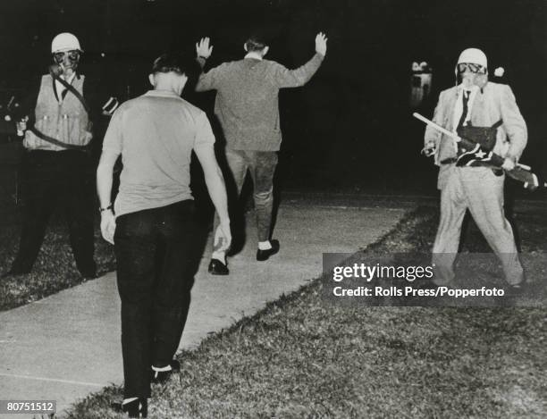 September 1962, Oxford, Mississippi, White student protesters are marched away by US,Marshalls wearing gas masks, after protests against black...