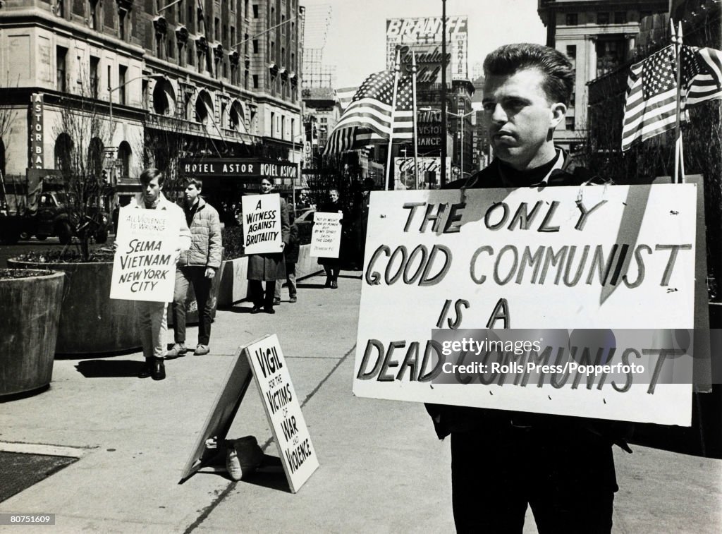Politics USA. pic: 17th April 1965. New York. A, anti-communist picket with a stark message as a rival demonstration peacefully moves alongside with it's message of peace and opposition to the Vietnam war.
