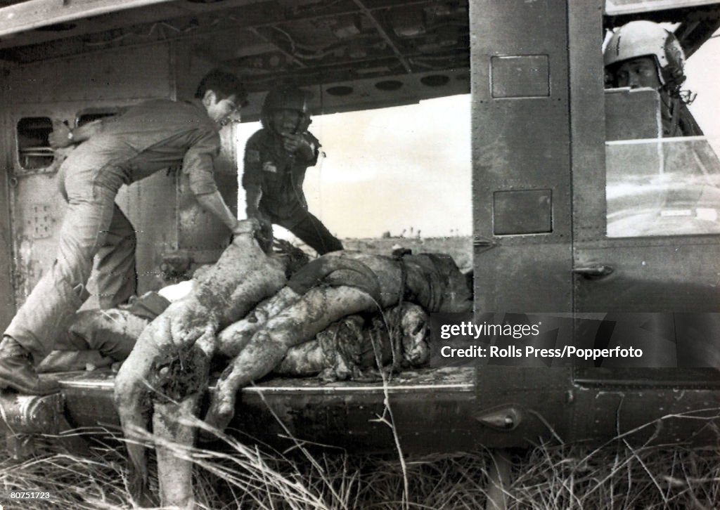 War and Conflict The Vietnam War. pic: 4th April 1975. near Son Nhut, South Vietnam. A helicopter crew load bodies on to the "chopper", these were some of the victims of a crashed American C5 "Galaxy" which had crashed en-route to the Philippines.