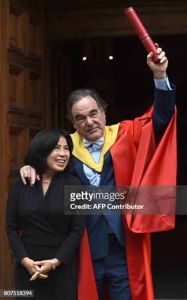 Film director Oliver Stone and his wife Sun-jung Jung react after he received an Honorary degree from the University of Edinburgh during a graduation...